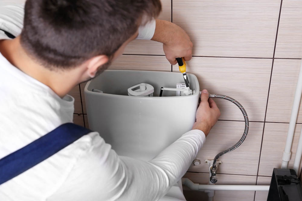 Express Trenchless technician working on toilet repairs